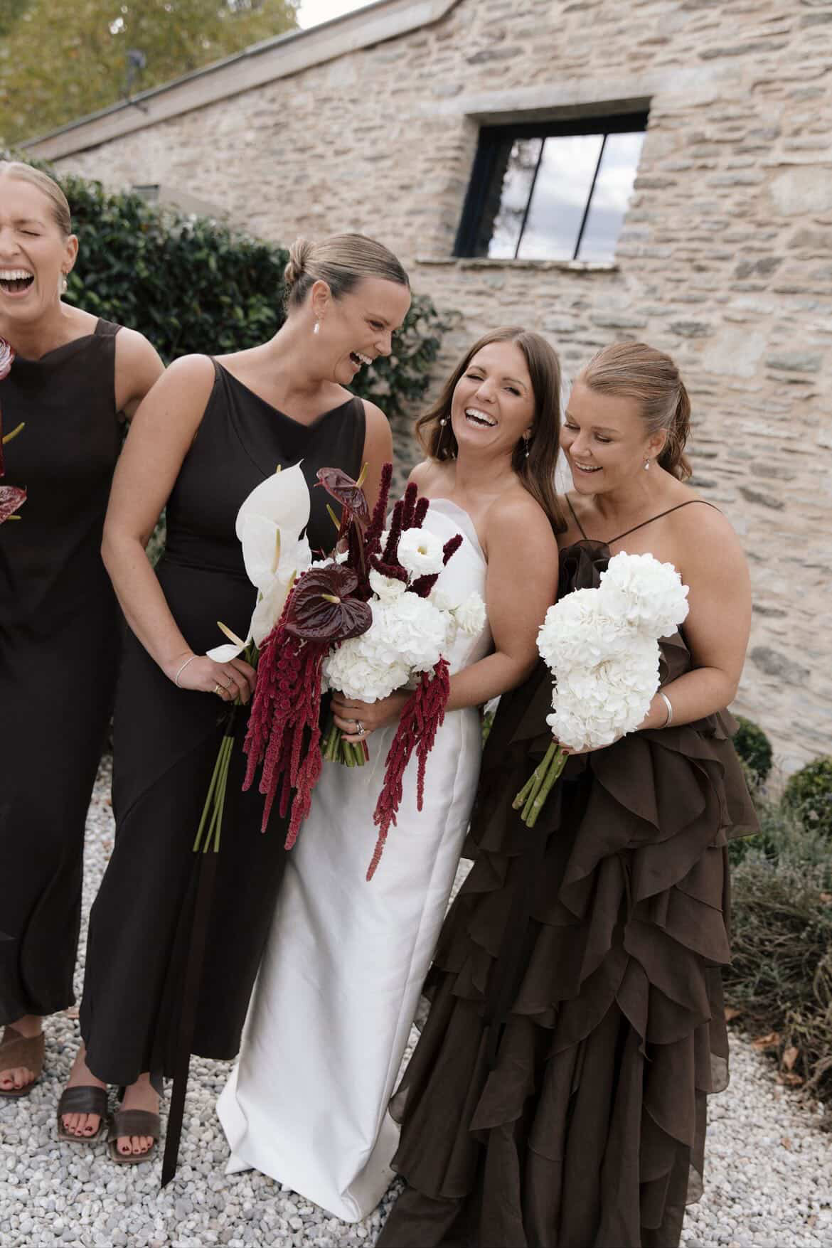Bride laughing with her bridesmaids
