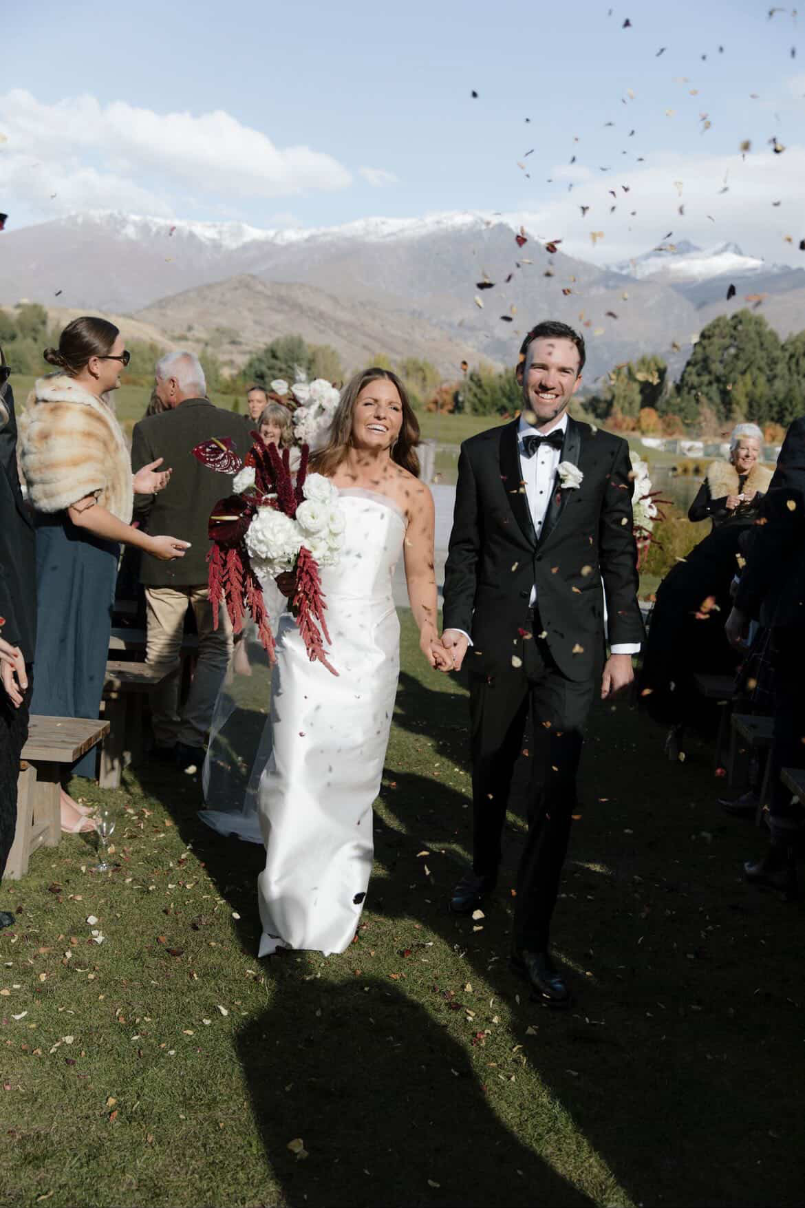 Bride and groom walking back down the aisle through confetti