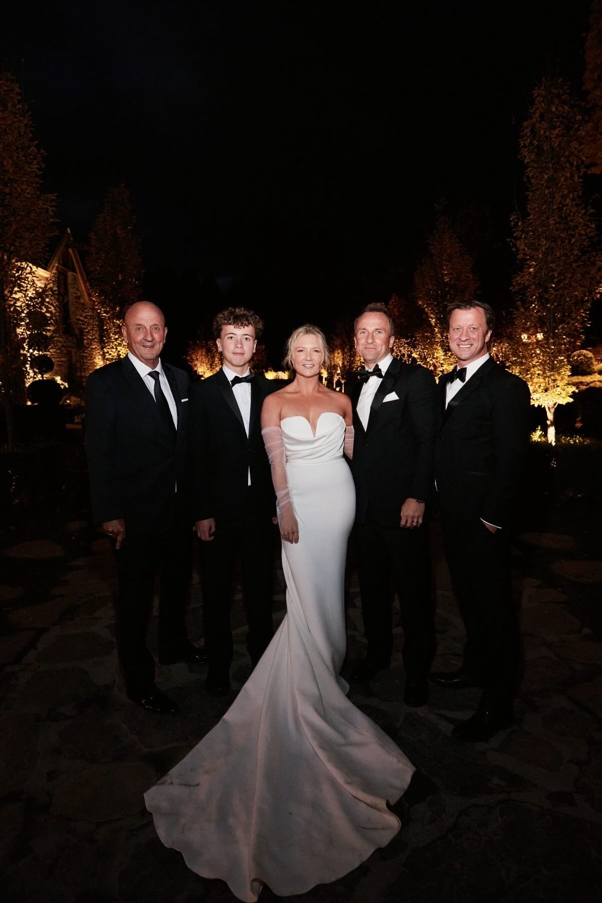 Bride with the groomsmen under the night lights