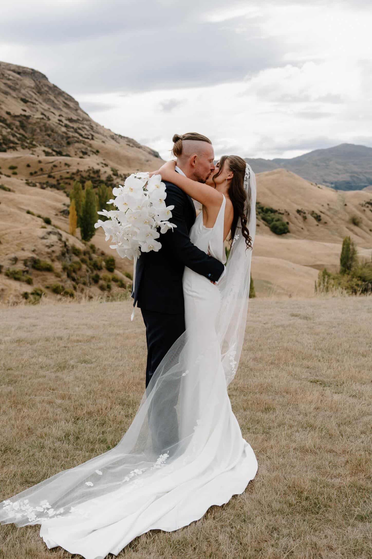 Bride and groom kissing in the golden hills
