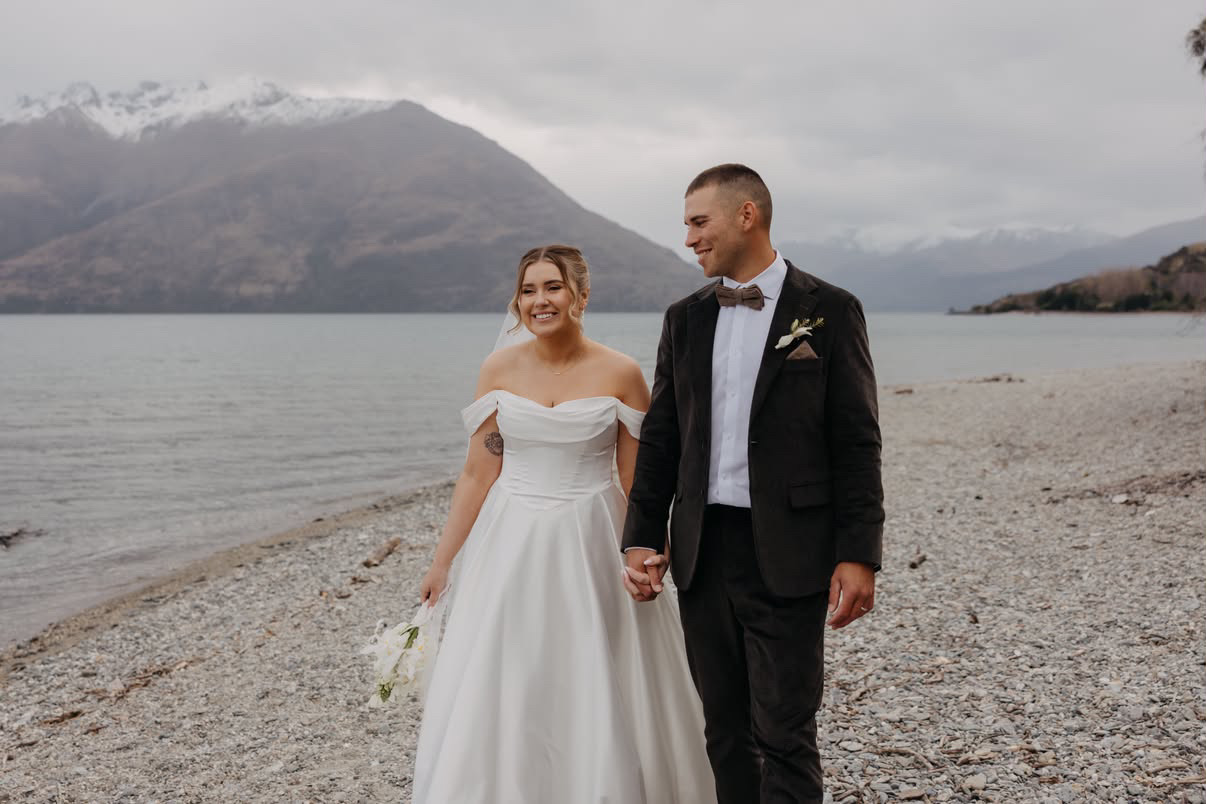 Bride and groom walking along the lakeshore