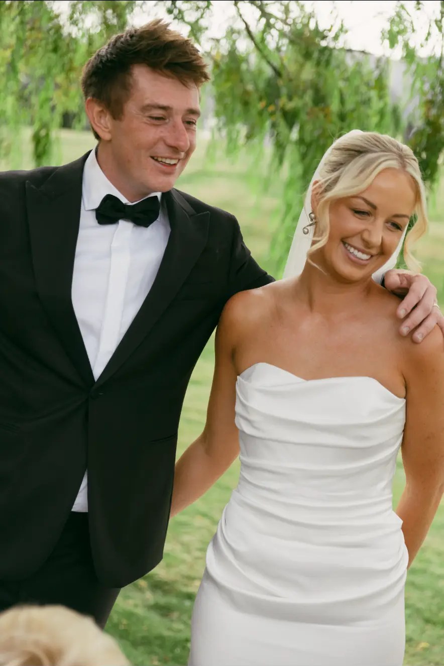 Bride and groom walking together, his arm around her