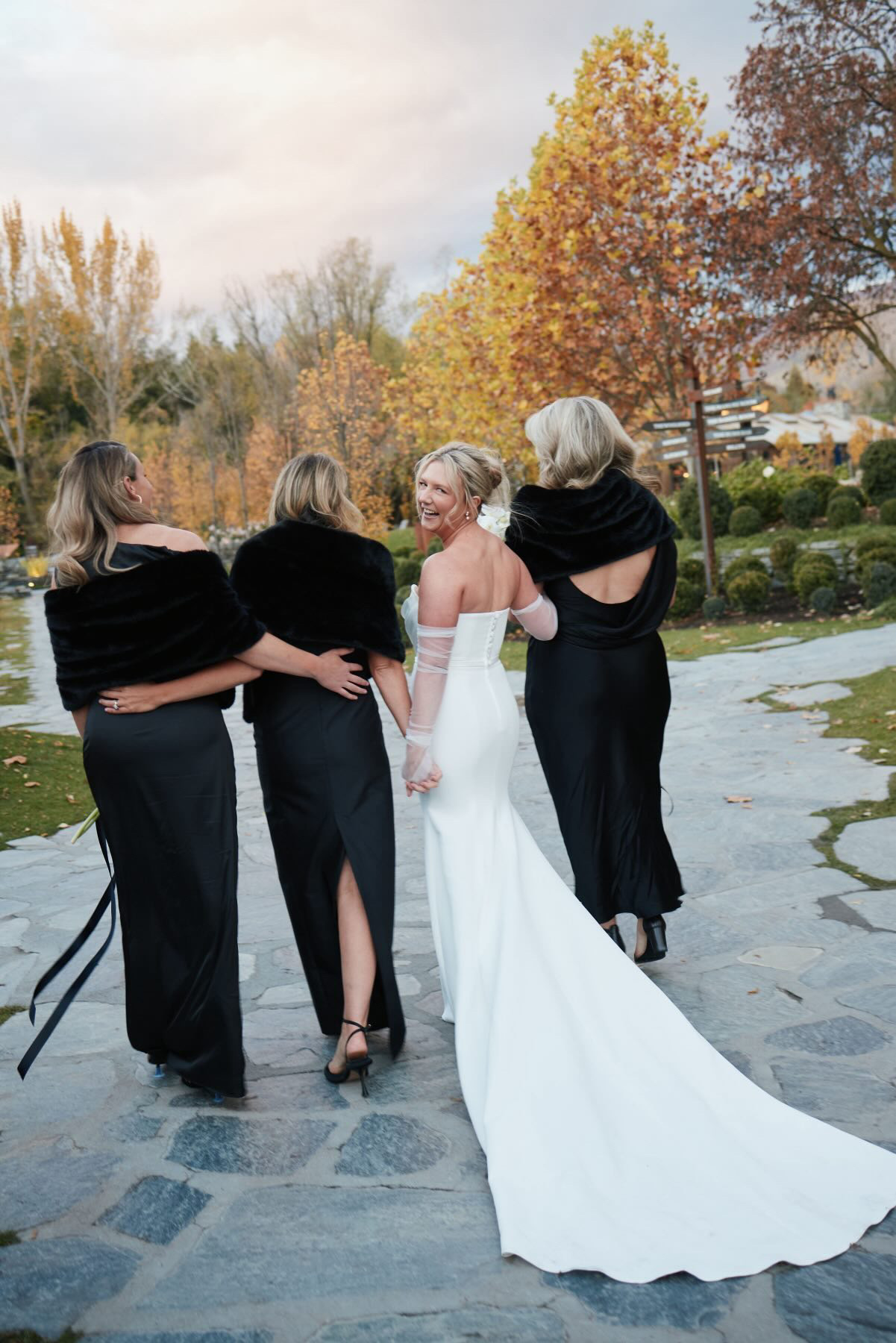 Bride walking with her bridesmaids in black